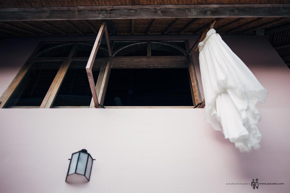 Ayu wedding dress hanging outside the window of Hacienda villa no 5 master bedroom