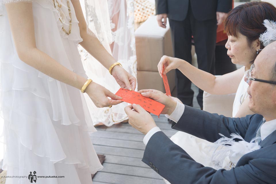 Father and mother give red envelope to bride