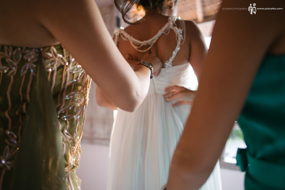 Bridesmaid fasten the wedding dress zipper