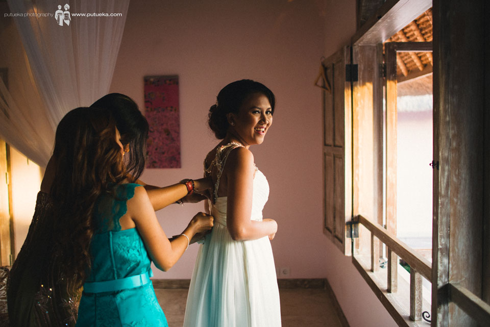 Bridesmaid help Ayu to fasten the wedding dress zipper