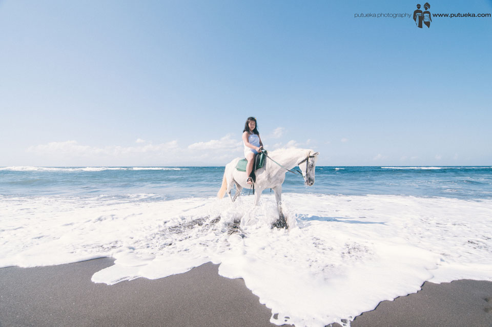 Bali family photography session with horse and wave splash on the beach