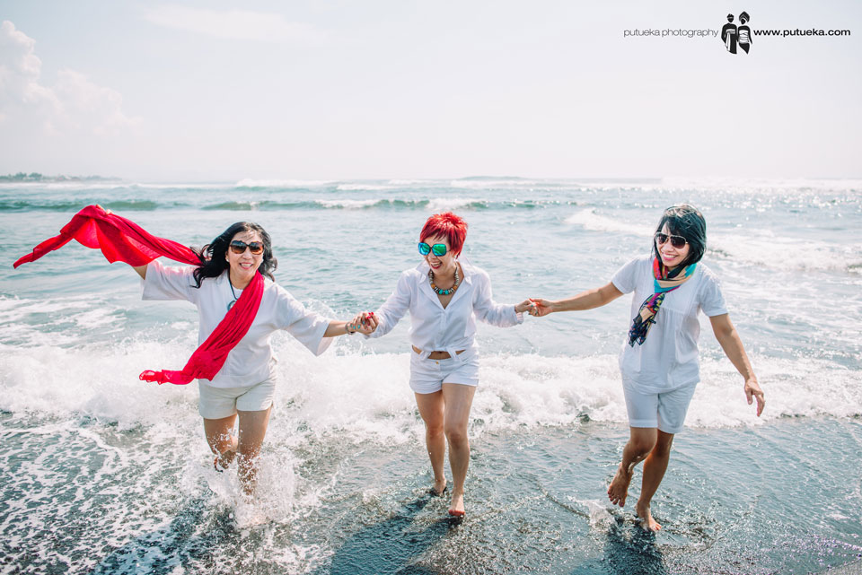 Annie and friends lauhing happily when their feet splash by the wave