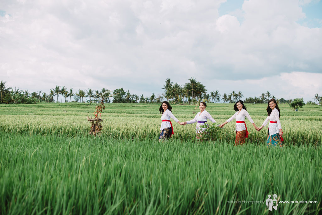 Holding hands inside the green ricefields for photo session